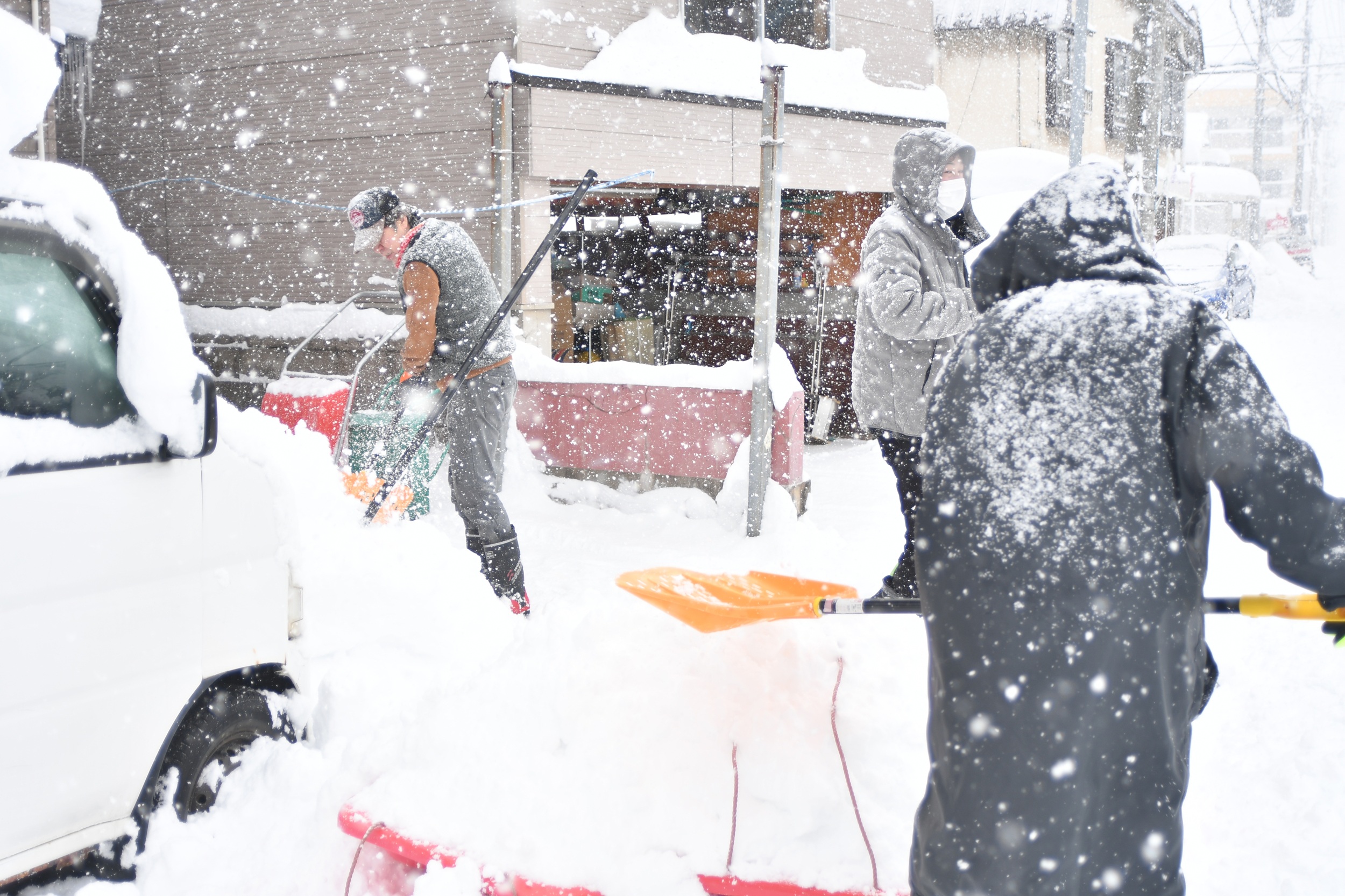 雪が降りしきる中、除雪作業をする青森市民＝１月２２日
