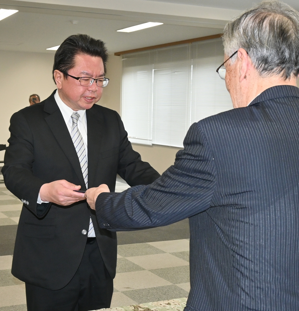 大沢寿一選管委員長(右)から当選証書を受け取る中平均氏=16日、久慈市役所