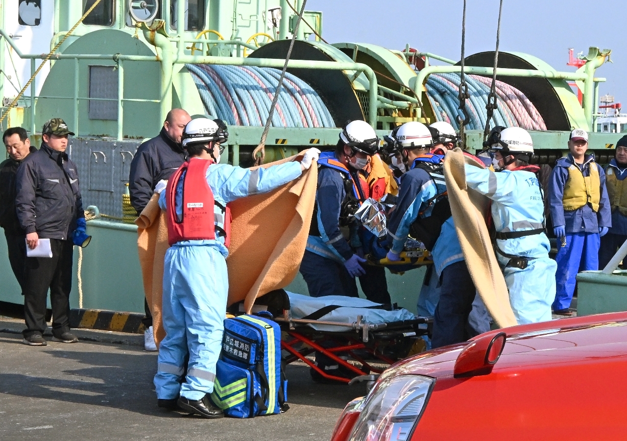 救助された漁船の乗組員を搬送する救急隊員=17日午前8時15分、八戸市江陽の第2魚市場前