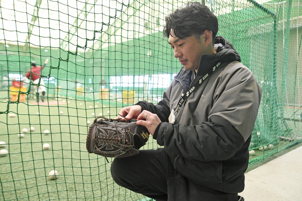 母校で野球用具のメンテナンスを行う北條裕之さん=3月上旬、八戸市