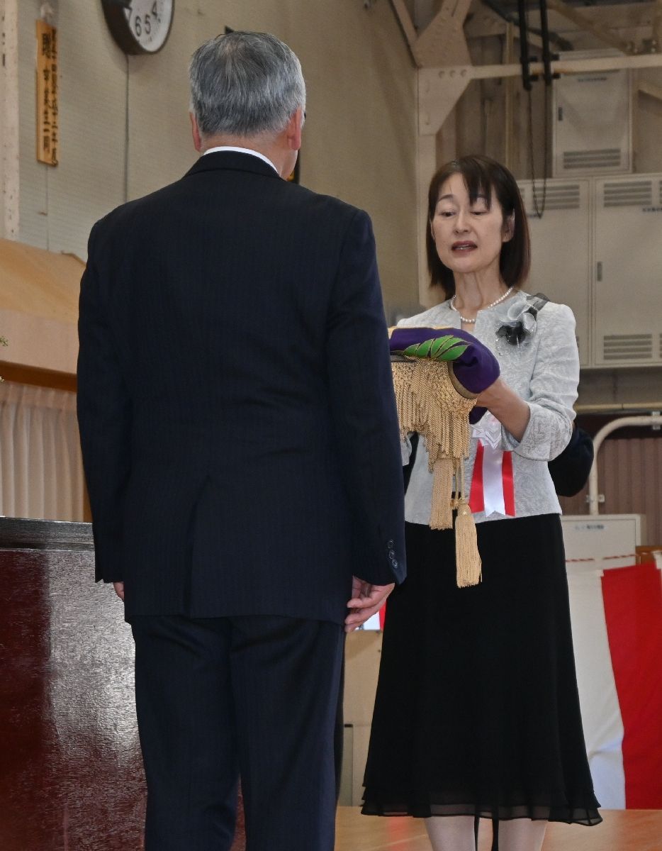 校旗を返納する佐々木美江子校長(右)