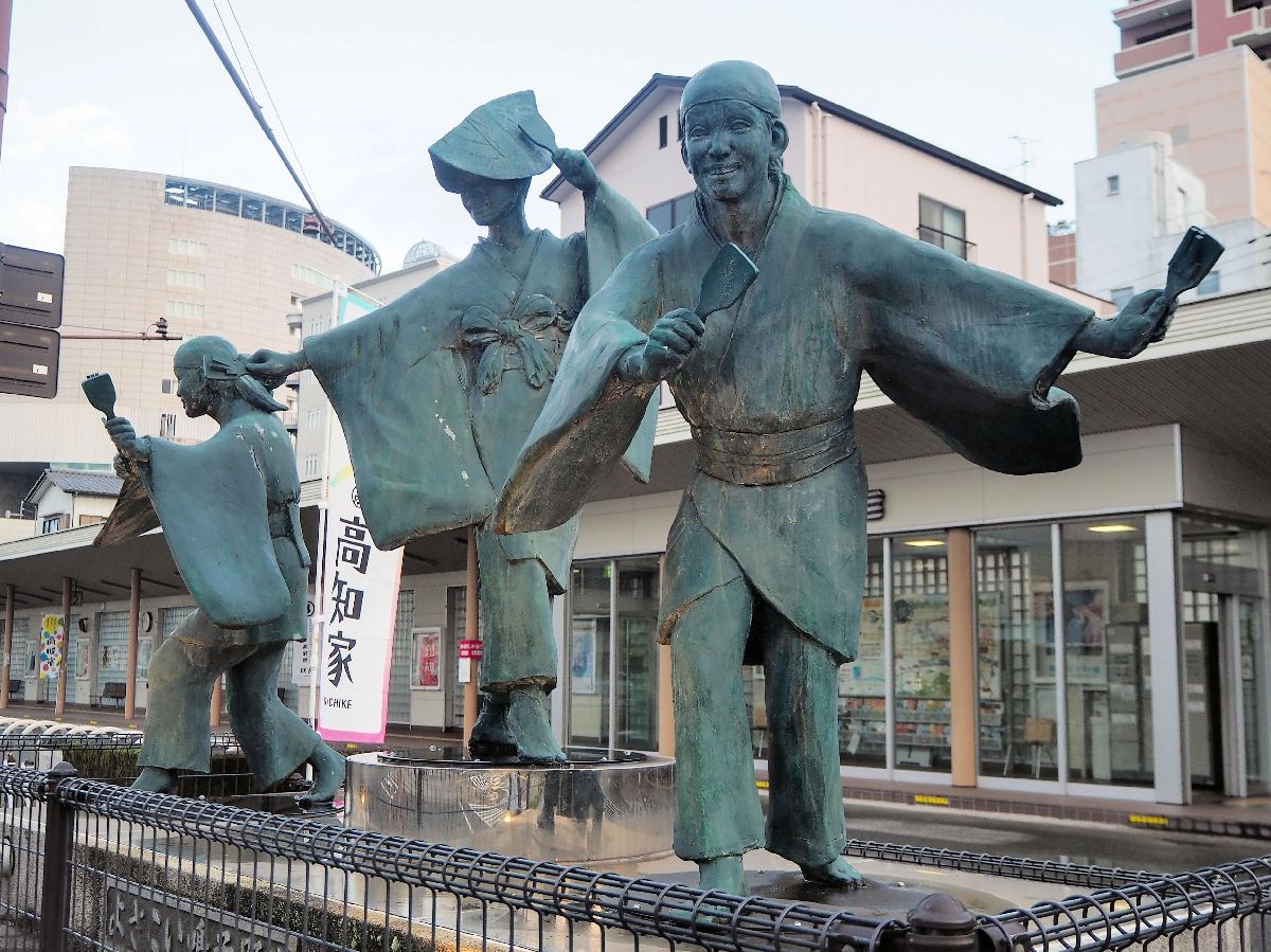 　鳴子を手に３人がおどる「よさこい鳴子踊り」の像＝高知市のはりまや橋観光バスターミナル