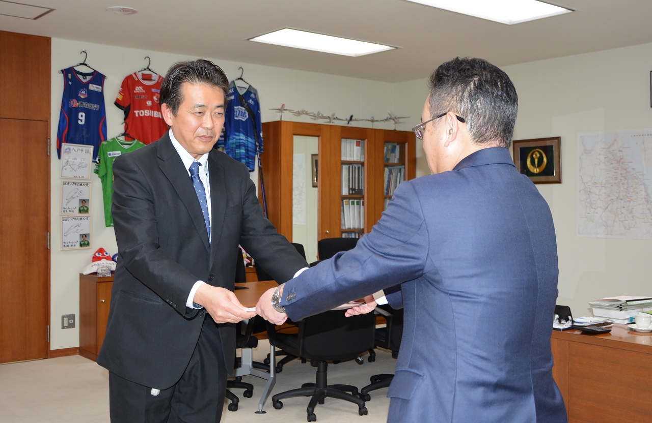 熊谷雄一市長（右）に推進プランの冊子を手渡す高橋史朗会長＝１９日、八戸市庁