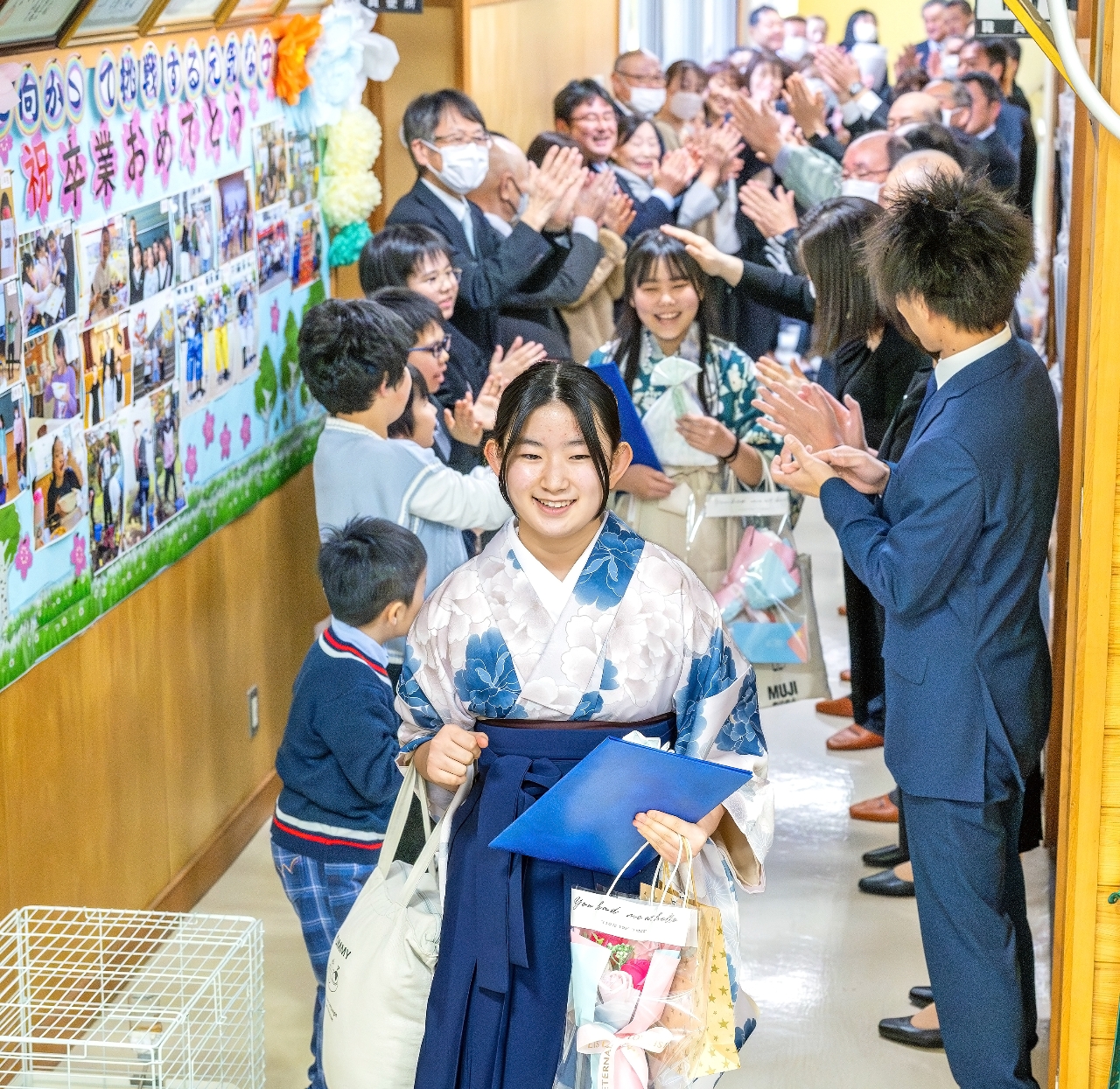 地域住民ら大勢の参加者に見送られ、学びやを後にする卒業生=19日、八戸市立金浜小(大粒来仁撮影)