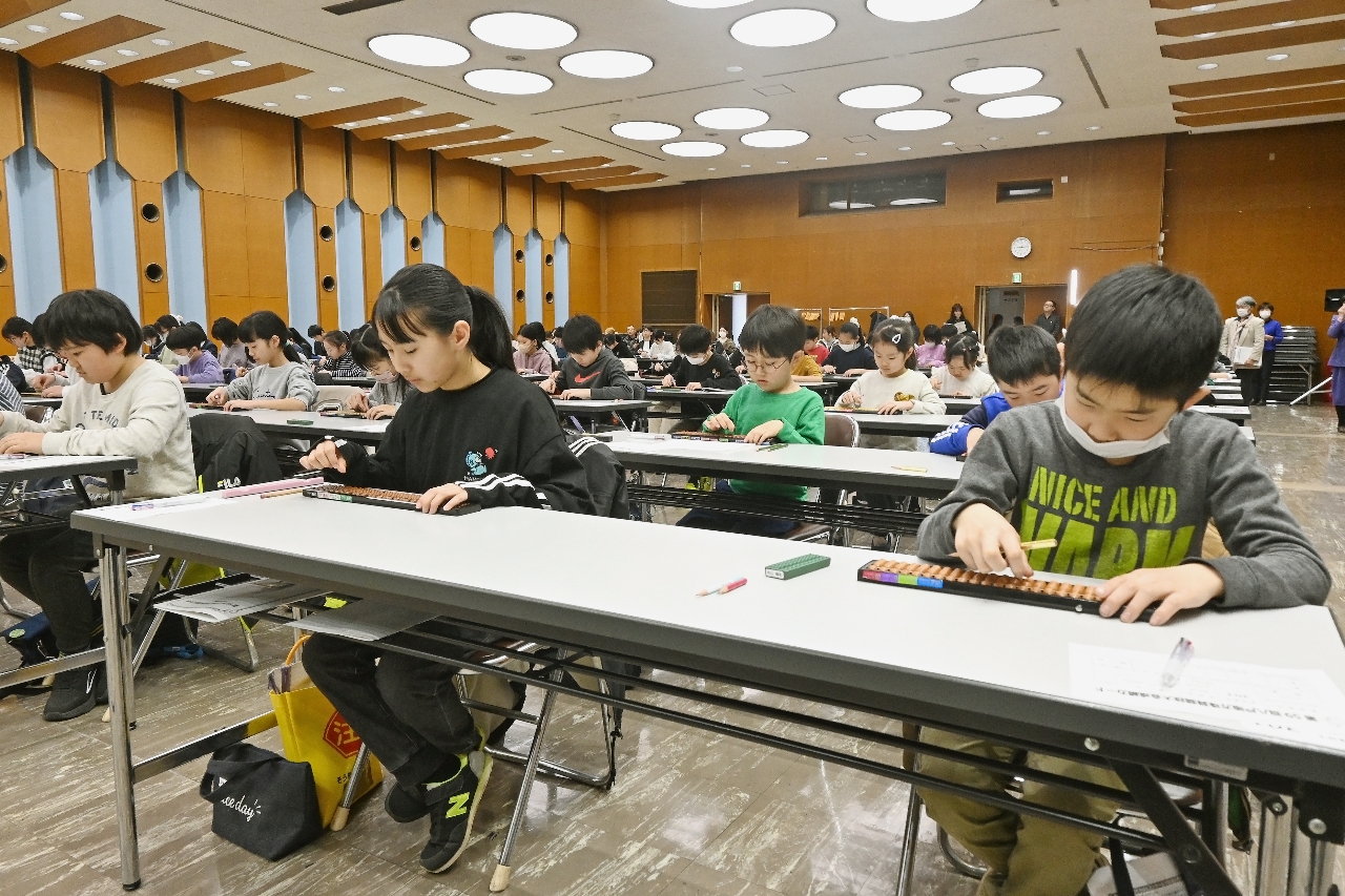 真剣な表情でそろばんをはじく参加者