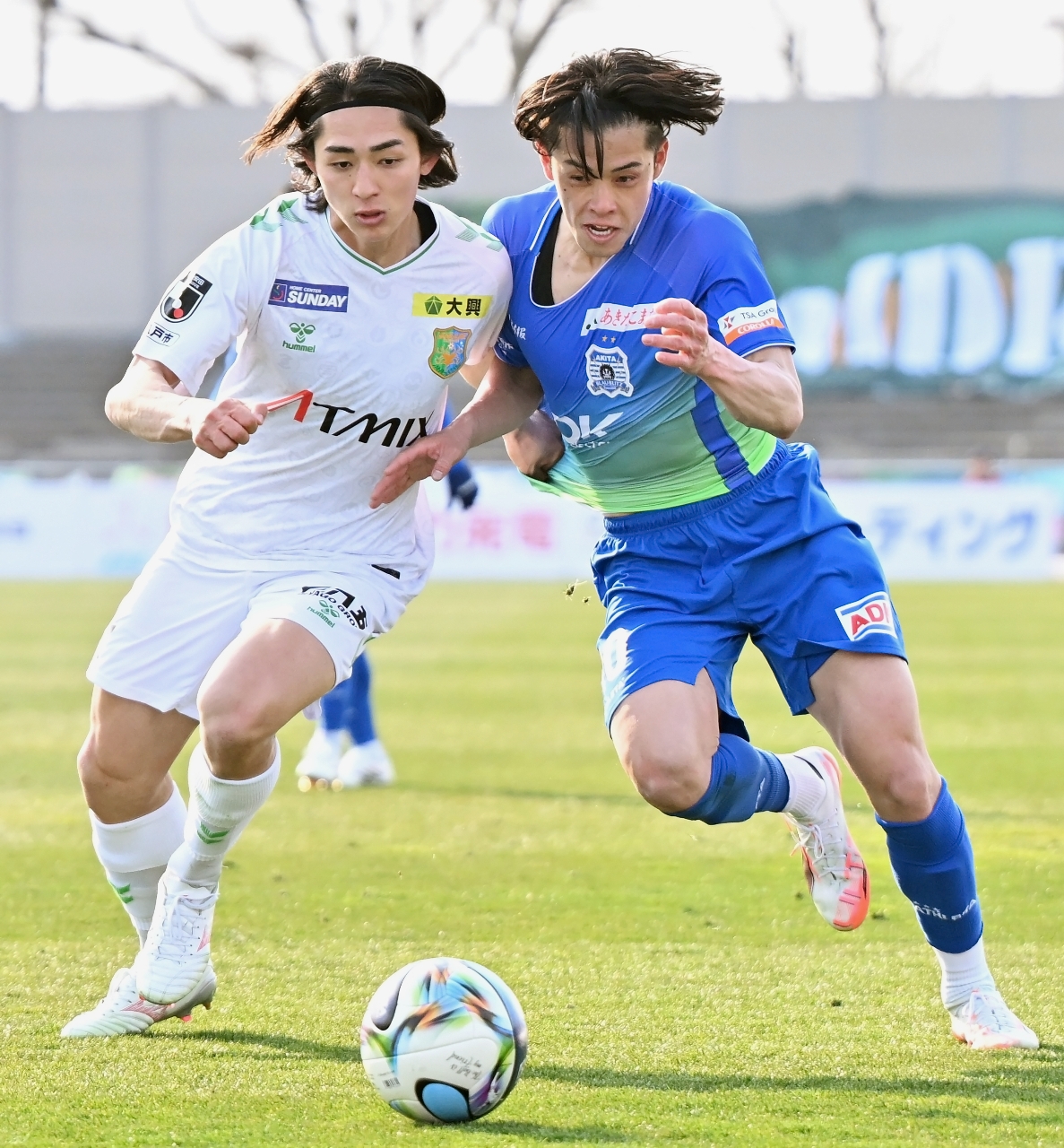 【ブラウブリッツ秋田―ヴァンラーレ八戸】後半、体を当てて相手の突破を阻むヴァンラーレＭＦの鈴木慎之介（左）＝ソユースタジアム