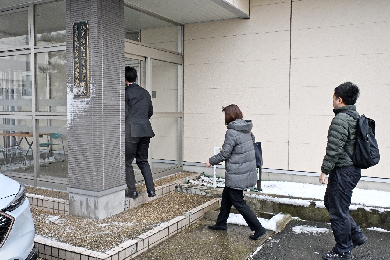 八戸機船漁協の事務所に入る船越海運の関係者=21日午前10時35分、八戸市鮫町