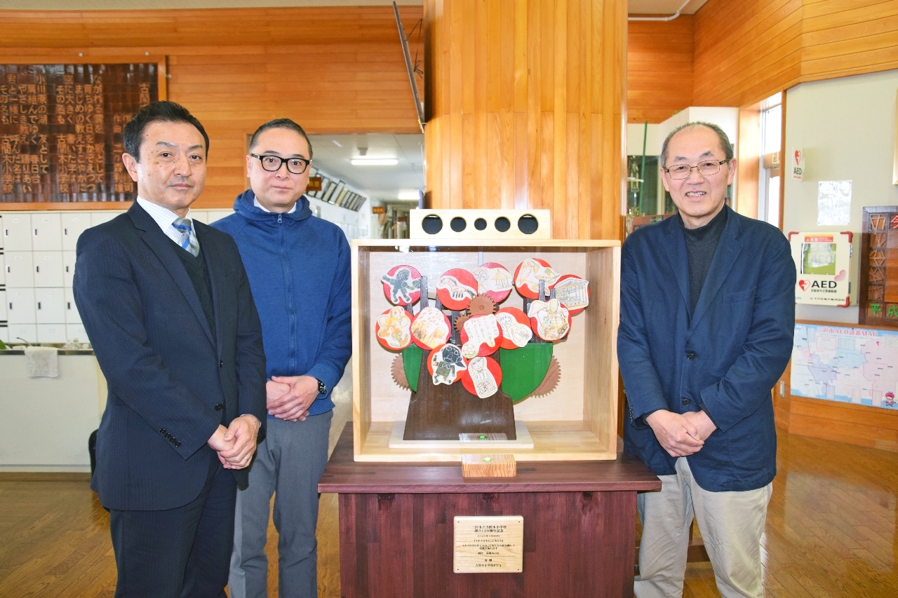 市立古間木小に設置されたからくり作品と(左から)松坂進校長、黒澤周一郎会長、高橋みのるさん