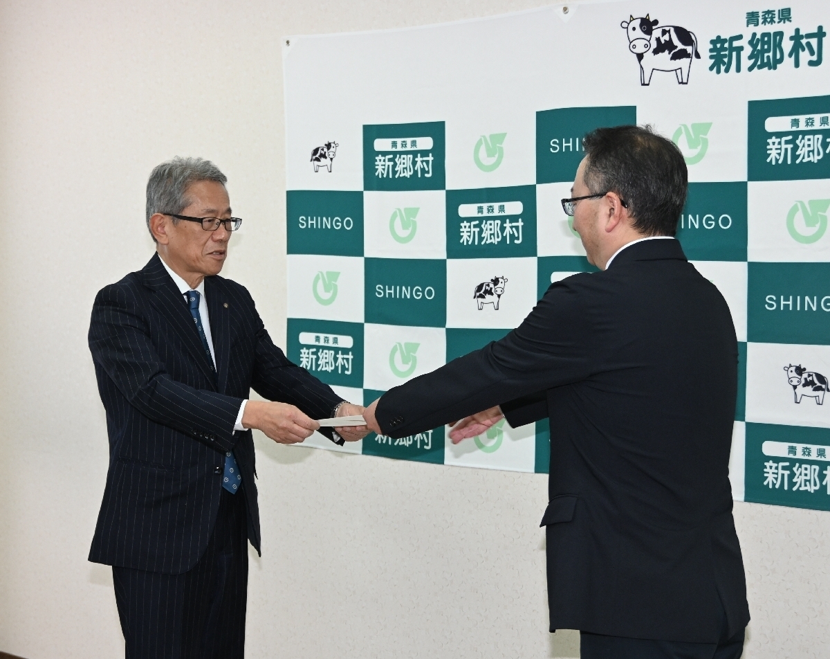 佐藤和友村長(右)に寄付採納願を手渡す堀内元博理事長