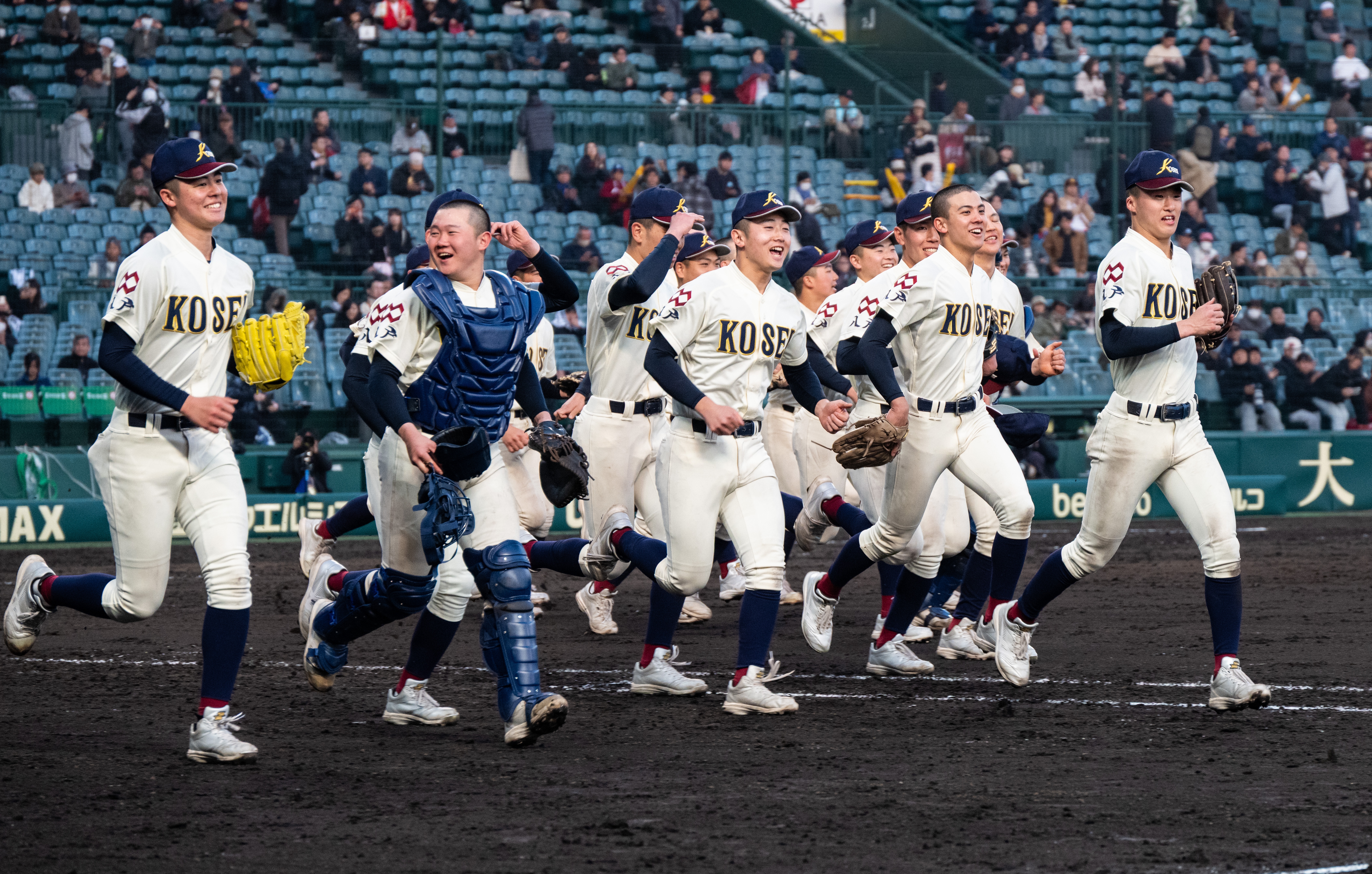 センバツ１回戦で崇徳を延長タイブレークの末下し、スタンドに駆け出す八学光星ナイン＝３月１９日、甲子園