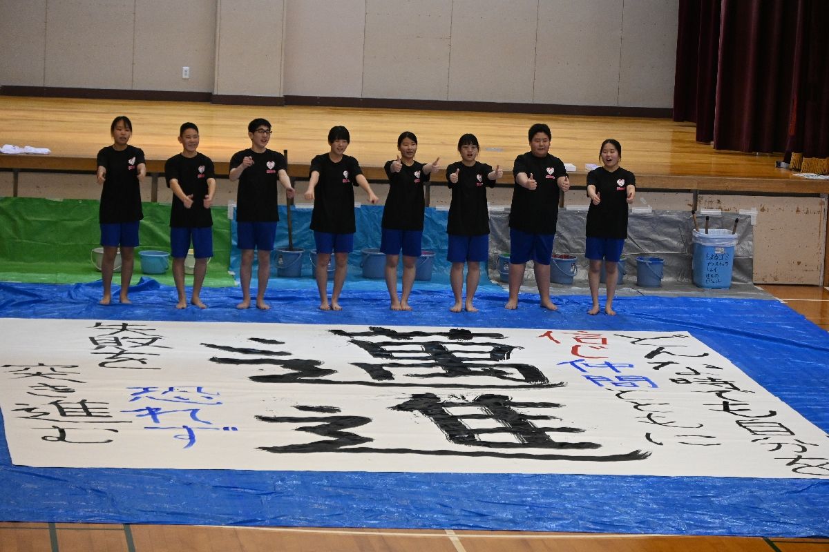 書道パフォーマンスを終え、ポーズをとる生徒たち