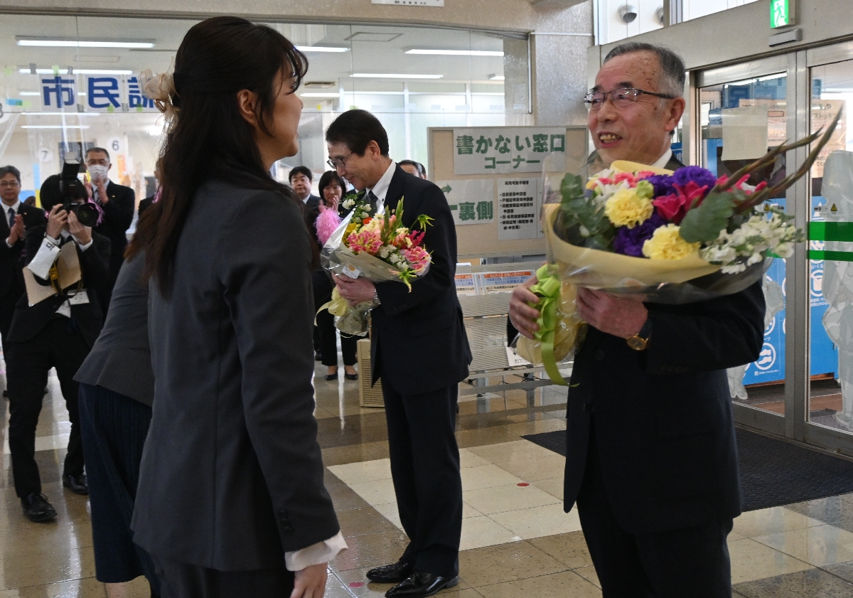 退任に当たって職員から花束を受け取った(右から)遠藤譲一市長、澤里充男副市長=25日、久慈市役所
