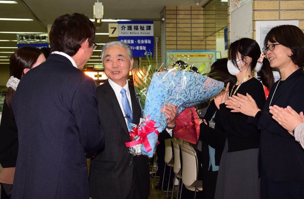 職員らに拍手で見送られる成田隆町長(中央)=25日、おいらせ町