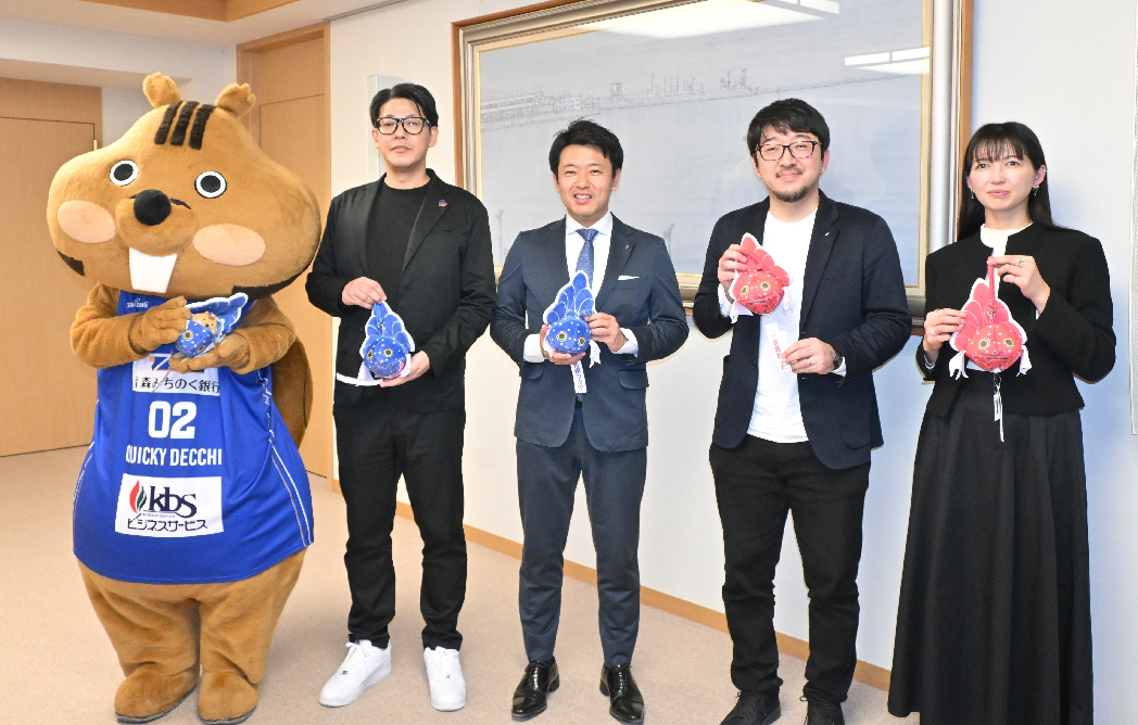 宮下宗一郎知事(右から3人目)にワッツカラーの金魚ねぷたポーチを紹介する渡邊裕介社長(同4人目)ら=25日、青森県庁