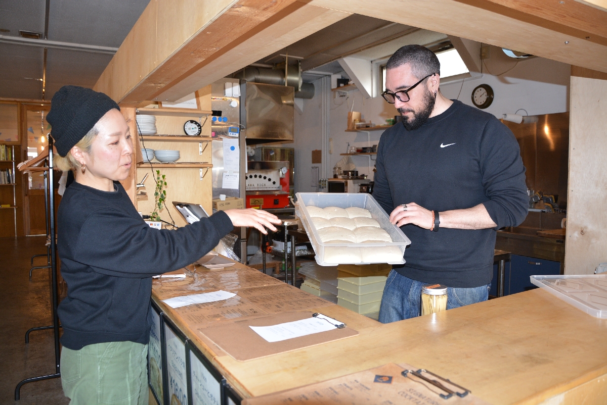 ピザ生地の仕上がりを確認するマリアーノ・ペロジーノさん(右)と三浦典子さん=3月下旬、十和田市