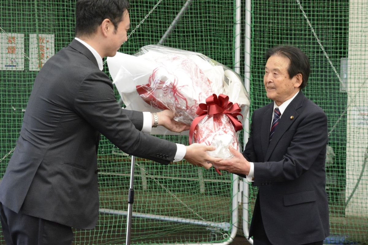 教室ＯＢから花束を受け取る妻神博明代表（右）