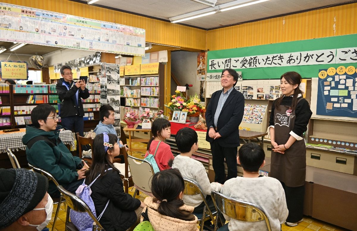 常連客らの前に立ち、閉店セレモニーに臨む工藤応之さん(右奥から2人目)。店員も交え思い出話を語り合った=29日、五戸町