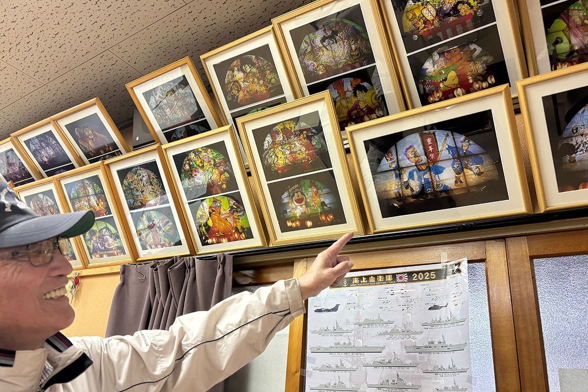 夏祭りで製作したねぶたの写真を眺める阿部弘さん=4月中旬、八戸市の河原木団地集会所