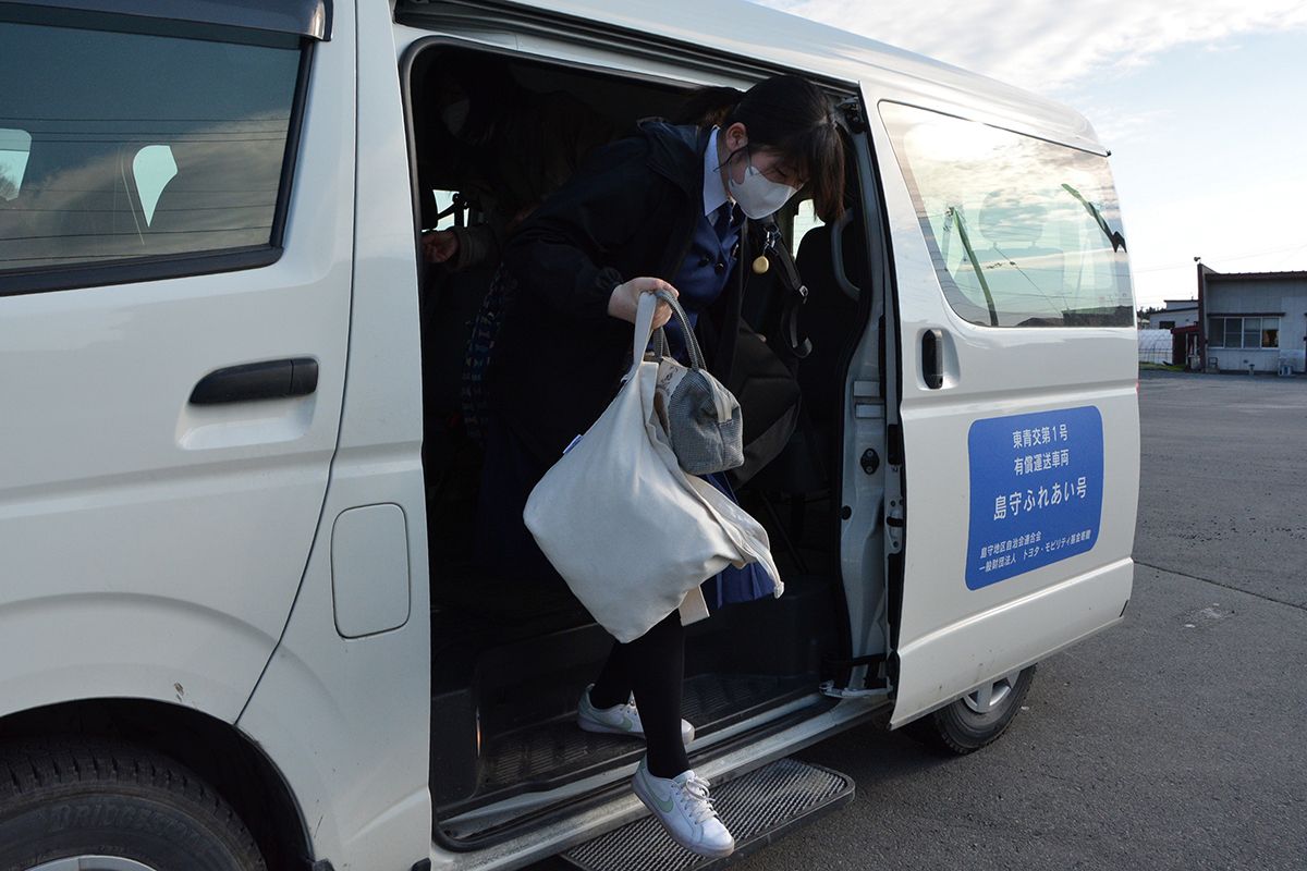 八戸市営バスに乗り換えるため、是川団地バス停に向かう堀井ひかりさん。「島守ふれあい号」は貴重な通学手段だ=4月下旬、同市