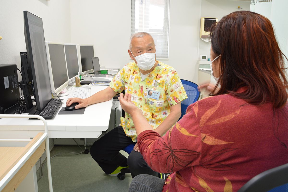 さいクリニックの診察室で患者と向き合う大竹進医師(左)=4月中旬、佐井村