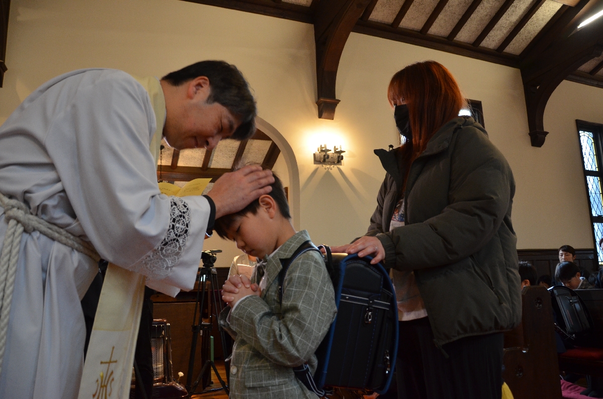 越山哲也司祭(左)から祝福を受ける新入生児童