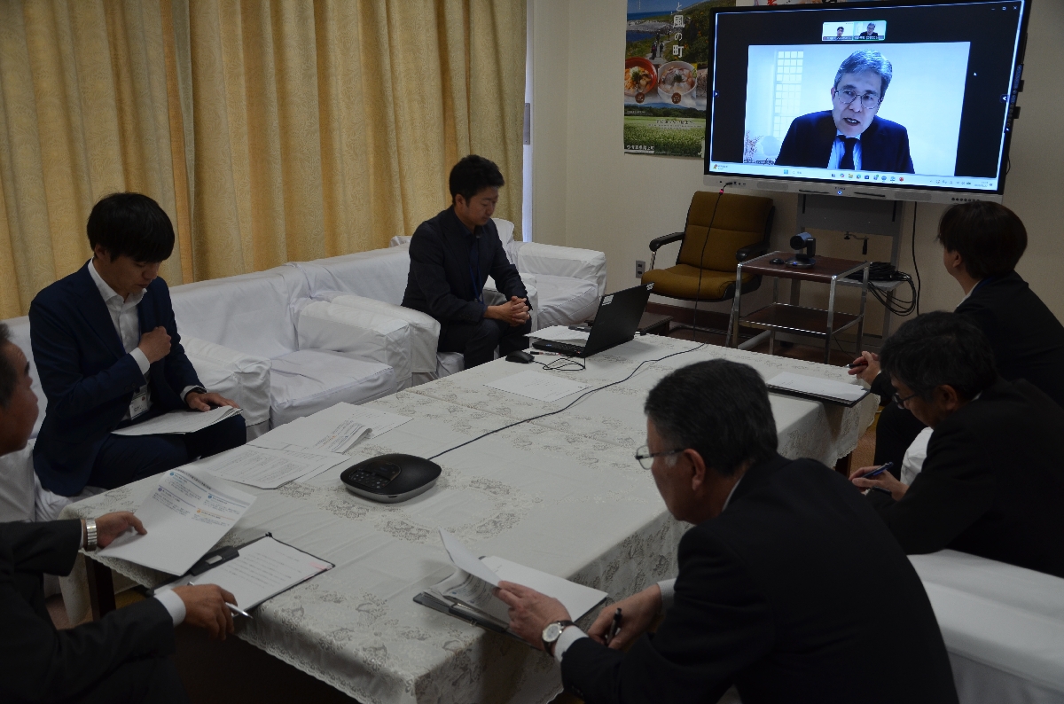 土谷伸司代表（画面）のコメントに耳を傾ける関係者