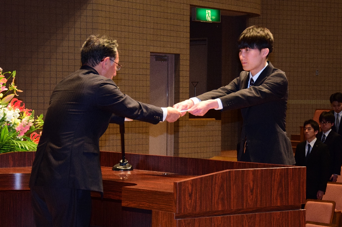 増田尚宏社長(左)から辞令を受け取る新入社員代表の石田響揮さん=六ケ所村