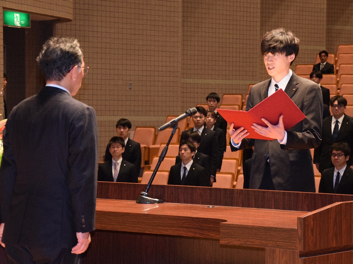 誓いの言葉を述べる新入社員代表の種市耕己さん（右）＝１日、六ケ所村