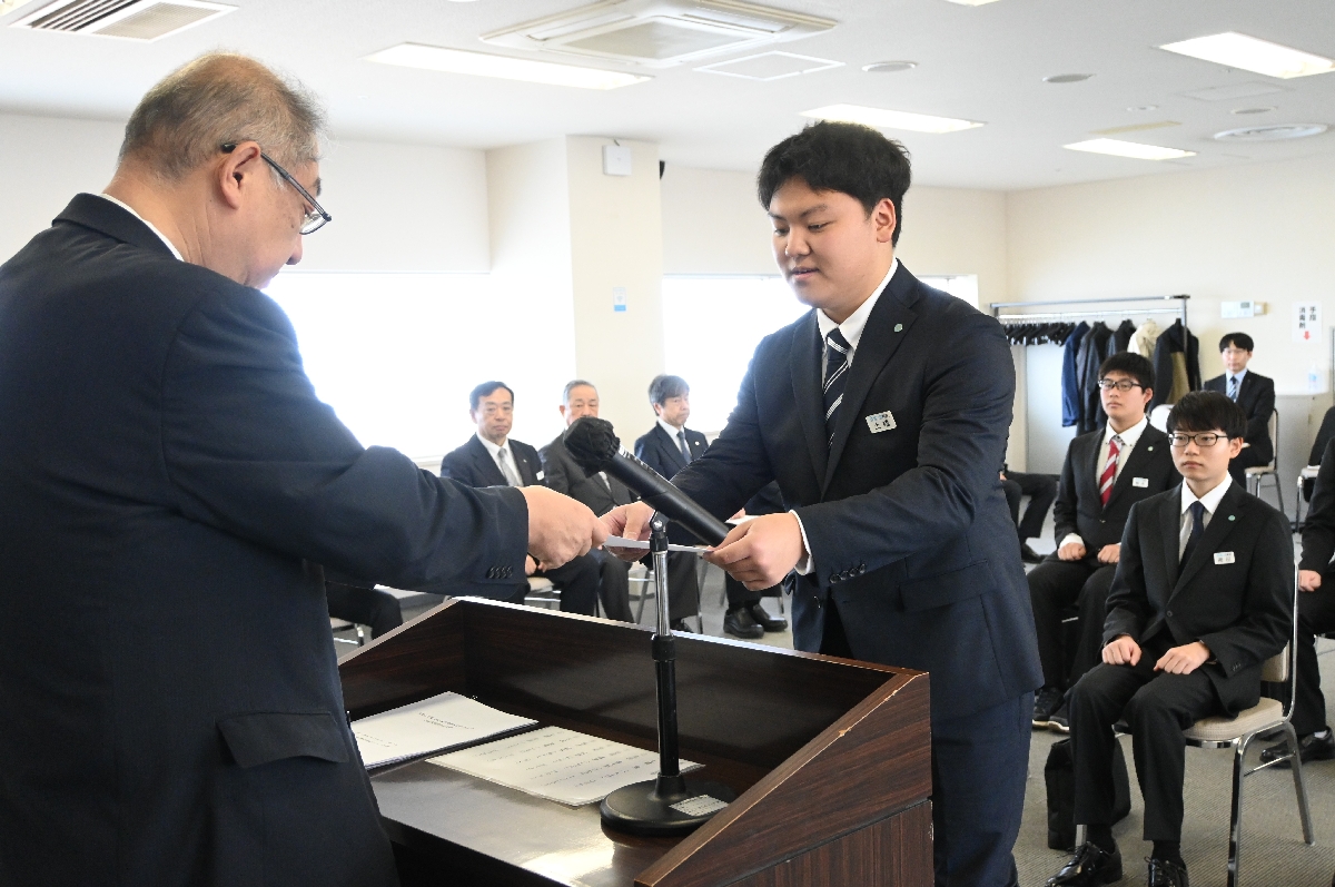 東直樹社長（左）から辞令を受ける土橋陽さん＝１日、青森市