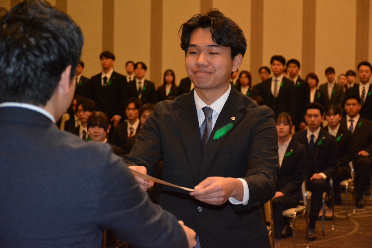 宮下宗一郎知事（左）から辞令を受ける新採用職員＝１日、青森市