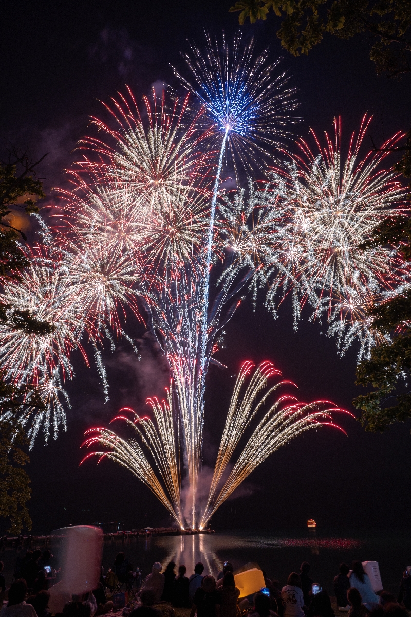 2024年の十和田湖湖水まつりで湖畔を彩った花火。今年は会期を2日間から1日に短くして開催する=同年6月8日、十和田市