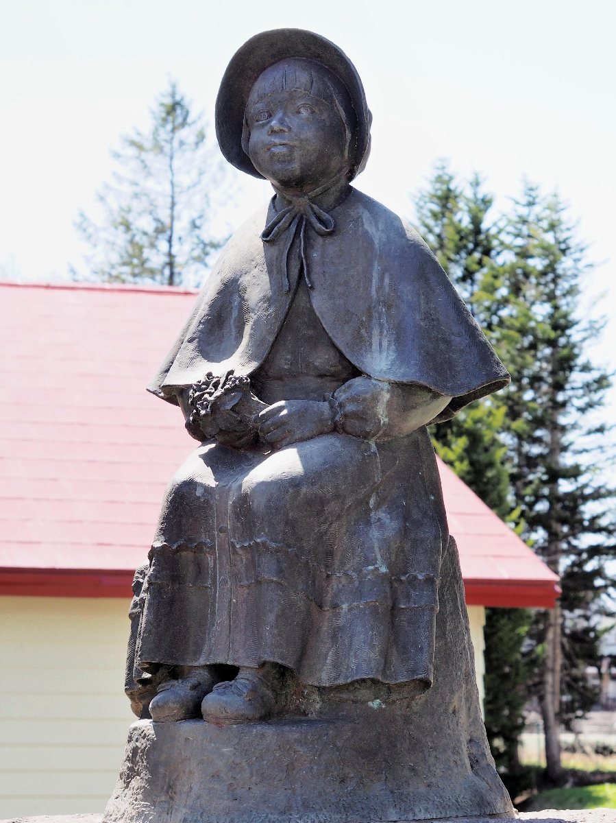 　母の像を見ているという岩崎きみの銅像＝北海道留寿都村の赤い靴公園