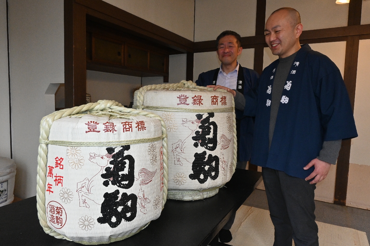 5月中にも復活する見込みとなった銘酒「菊駒」の樽と三浦弘文さん(右)=6日、八戸市