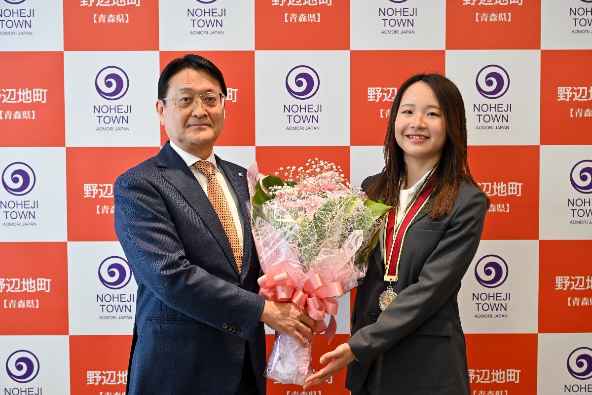 野村秀雄町長（左）に競技引退を報告し、花束を贈られる横濵汐莉さん