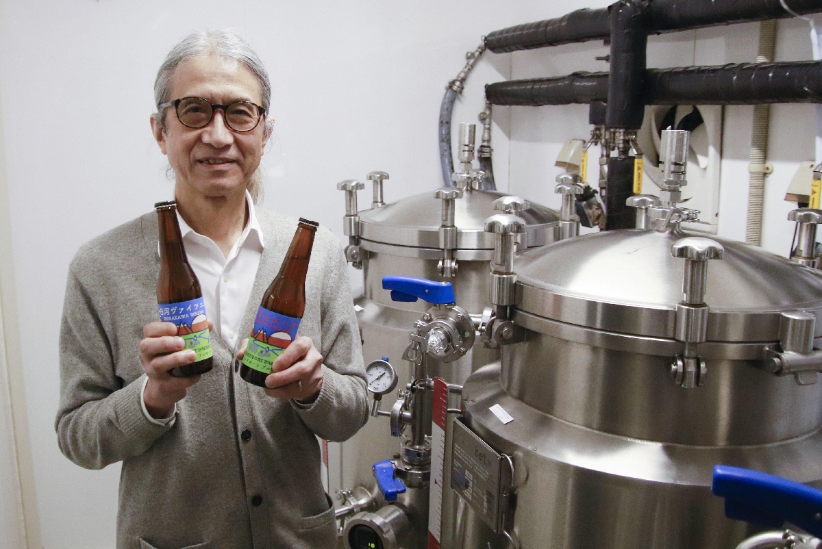 自宅裏の倉庫を改装した醸造所で、クラフトビールを手にする大谷辰夫さん=2日、福島県西郷村
