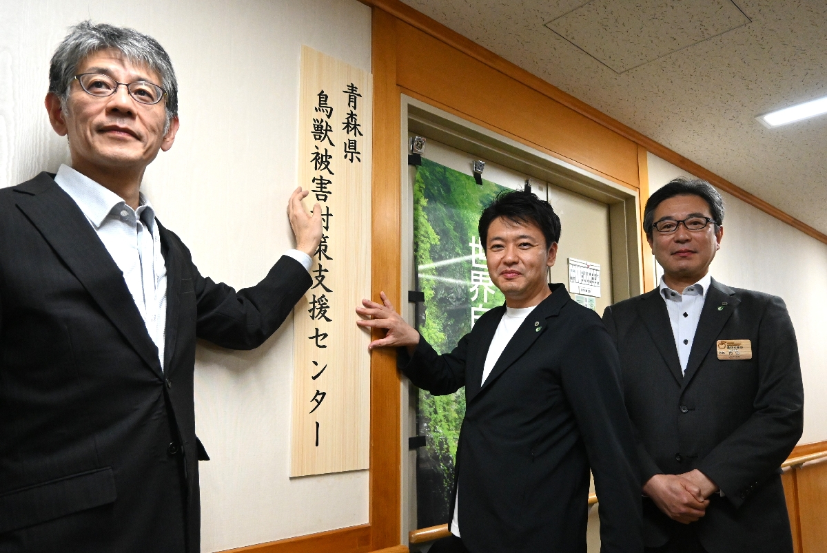 鳥獣被害対策支援センターの看板を設置する宮下宗一郎知事(中央)ら=10日、青森県庁