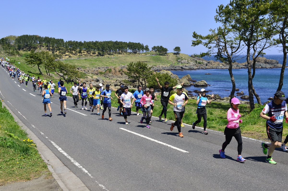 これまでで最も多い6460人がエントリーした第35回大会で、ハーフのコースを走るランナー=2016年5月