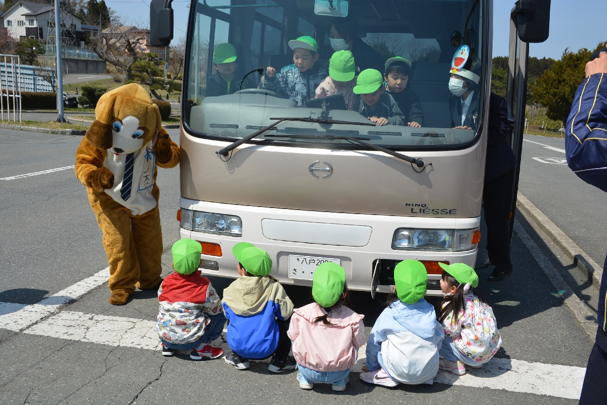 運転席側から、バスの下にしゃがみ込んだ友達の姿が見えるか確認する園児