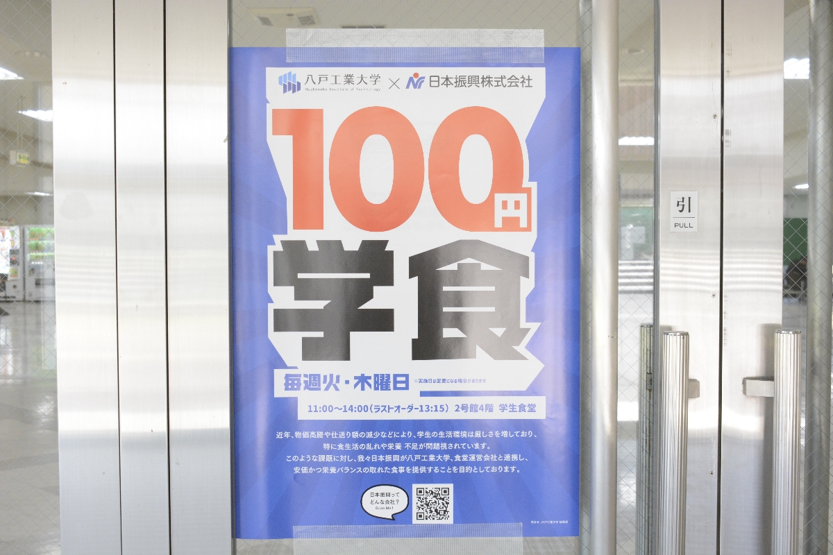 学内に掲示された「100学食」のポスター=14日、八戸工業大
