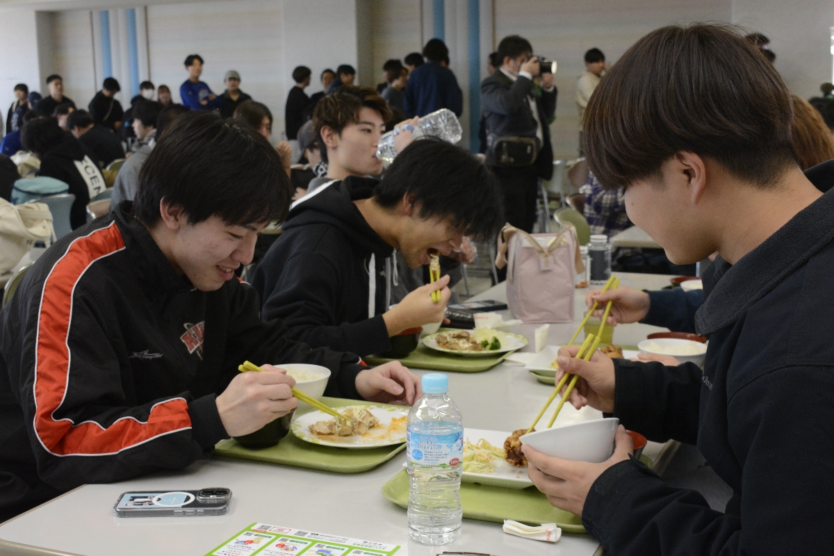 100円学食を味わう学生=14日、八戸工業大