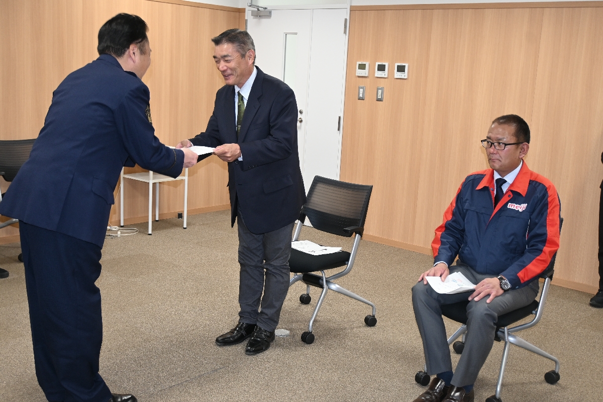 大倉德詩署長(左)から委嘱状を受け取る下舘佳光さん(中央)と工藤琢生代表