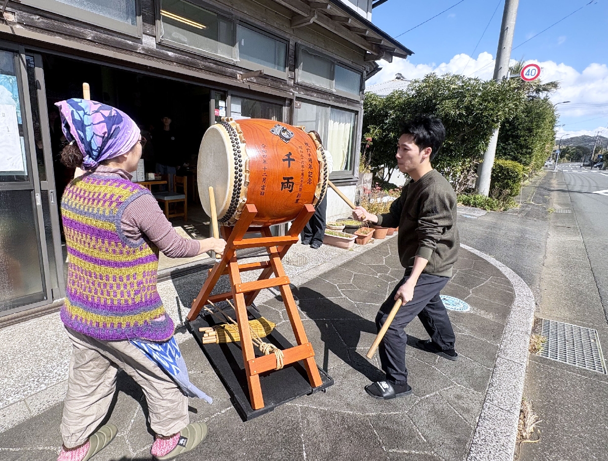 青空の下、店先で八丈太鼓を演奏する渡辺志保さん(左)と晴万さん=東京都八丈町