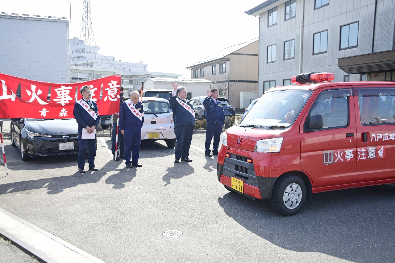 出発式で車両を見送る関係者