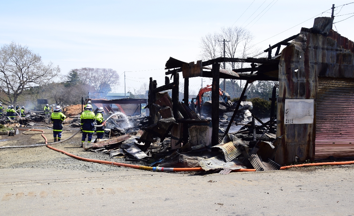 焼け落ちた牛舎と小屋=23日午前11時40分ごろ、東北町数牛