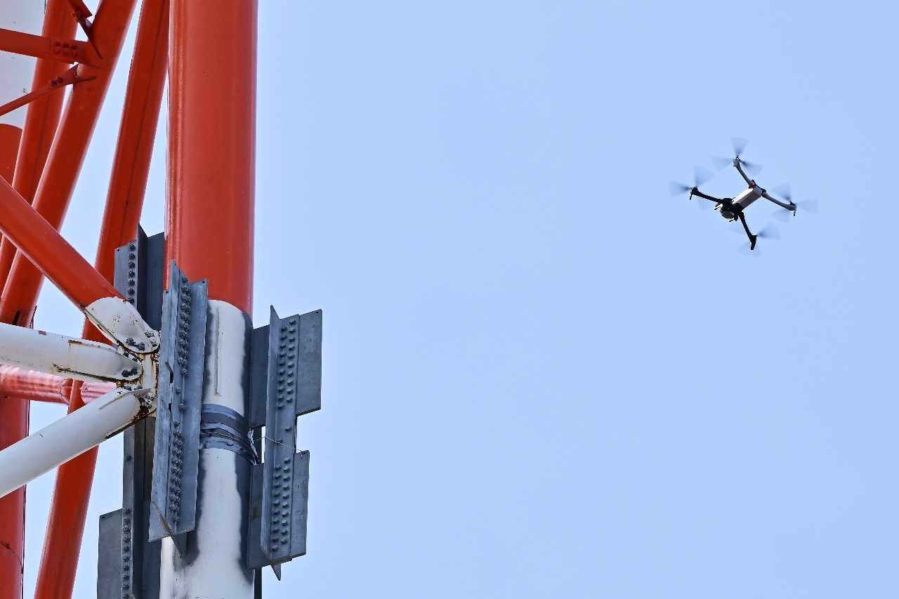 NTT青森八戸ビルにある鉄塔の点検をするドローン=23日午前11時半ごろ、八戸市