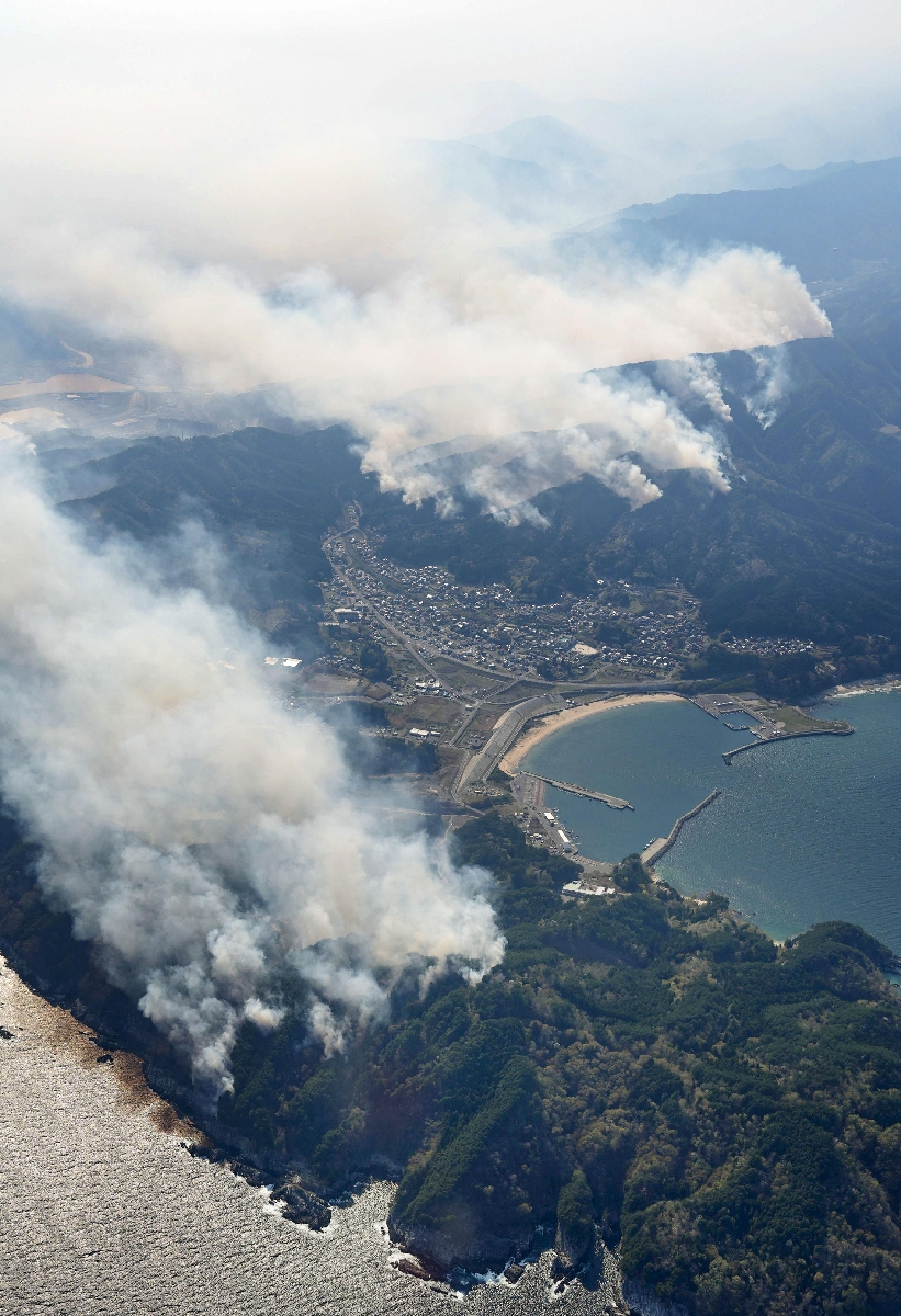 　白煙が上がる岩手県大槌町の山林火災現場。延焼が広がり、平成以降で国内２番目の規模となった＝２４日午後２時４９分（共同通信社機から）