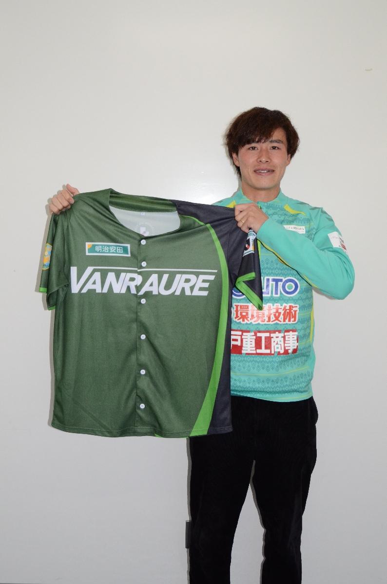 抽選でプレゼントするベースボールシャツを手に、来場を呼びかけるヴァンラーレ八戸のＤＦ澤田雄大＝八戸市プライフーズスタジアム