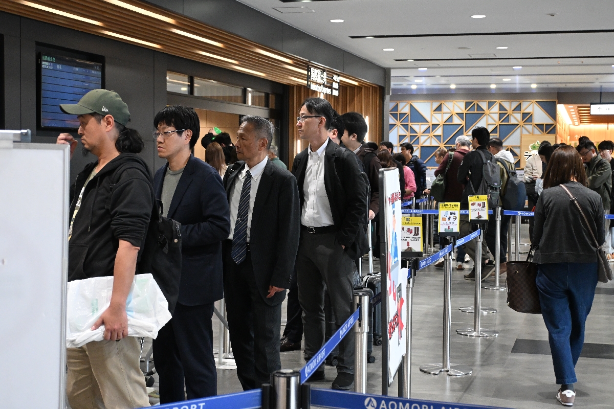飛行機の搭乗前に検査場に向かう利用者ら=24日、青森空港