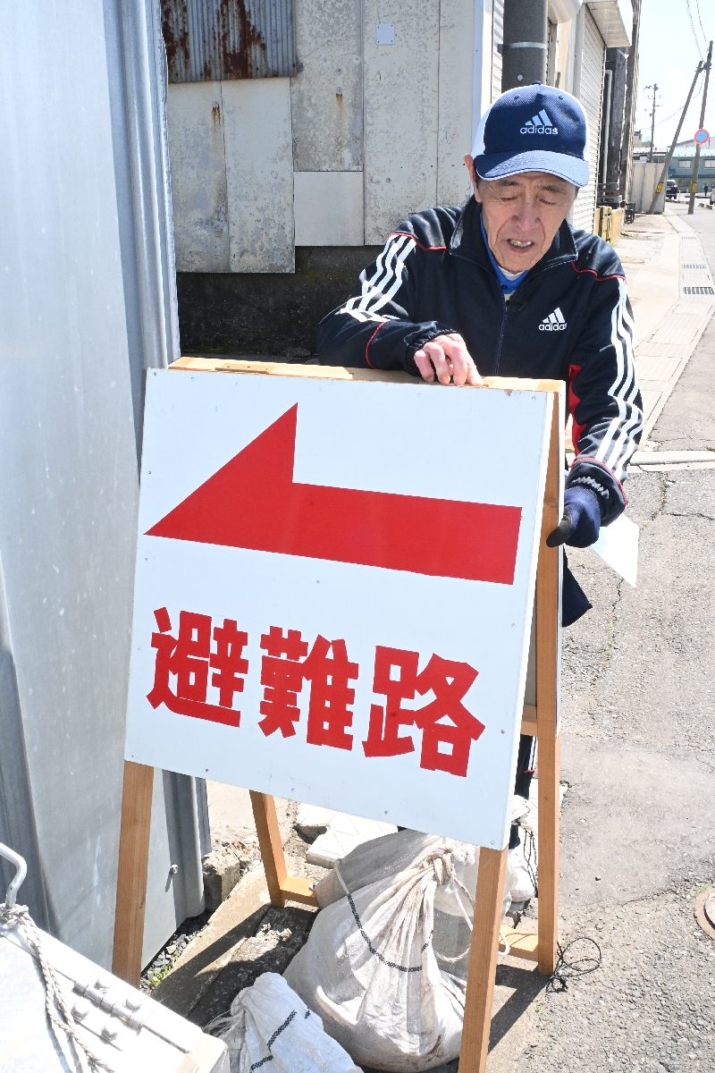 蕪嶋まつりの会場で、新たに設定した避難経路に看板を設置する関係者＝２４日、八戸市鮫町