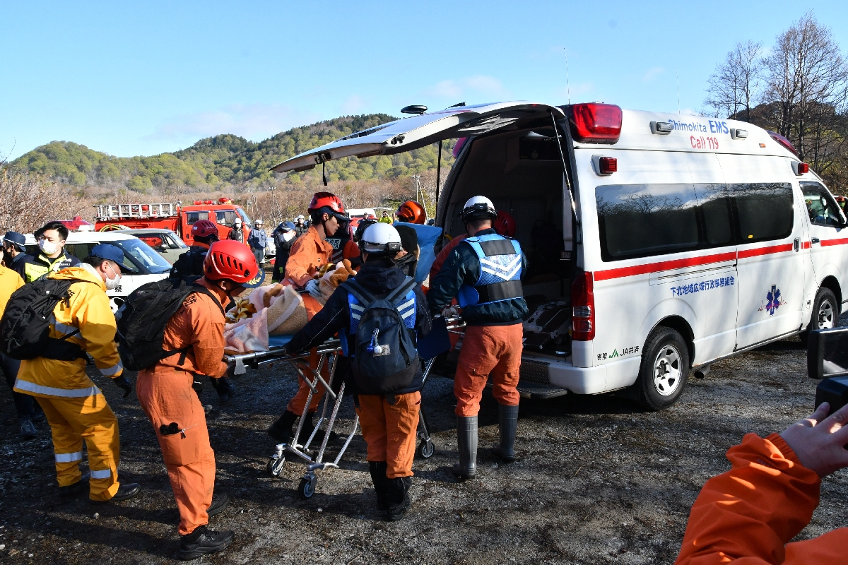 恐山で遭難した男性が見つかり、搬送する救急隊員ら＝２５日午前６時４０分ごろ、むつ市
